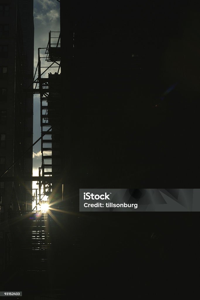 Fire Escape Alley Silhouette Fire escape silhouetted against setting sun. Perfectly copy ready. Alertness Stock Photo