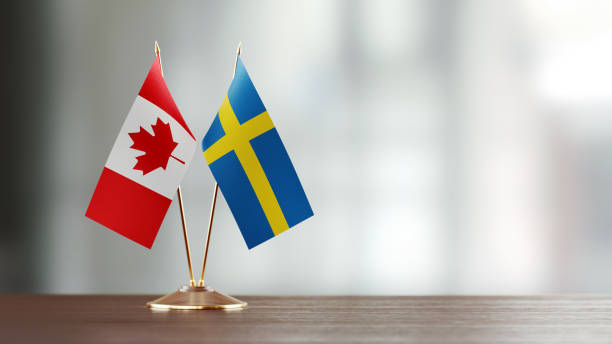 istock Swedish And Canadian Flag Pair On A Desk Over Defocused Background 931526438