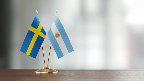 istock Swedish And Argentinian Flag Pair On A Desk Over Defocused Background 931526608