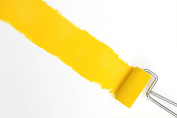 Single streak of yellow paint with rollers over white stock photo