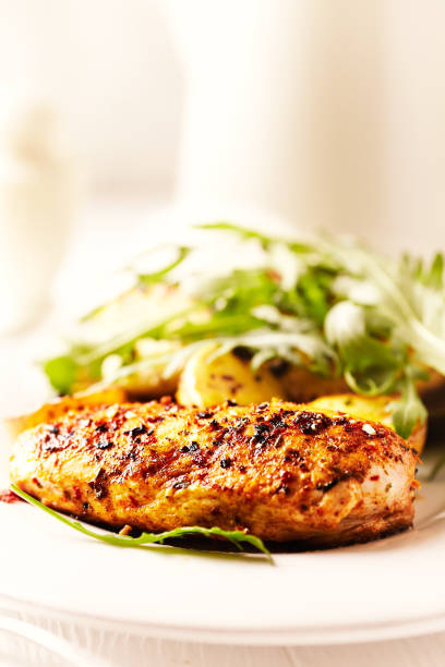 istock Spicy chicken breast with baked potatoes and arugula 931528064