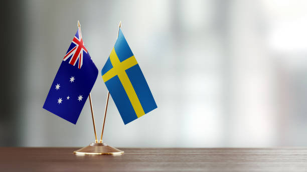 istock Swedish And Australian Flag Pair On A Desk Over Defocused Background 931528352
