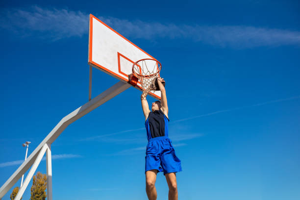 istock Young Basketball street player making slam dunk 931530990