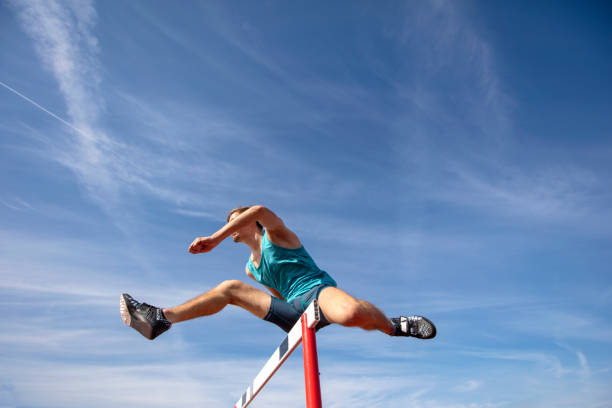 istock Low angle view of determined male athlete jumping over a hurdles 931531180