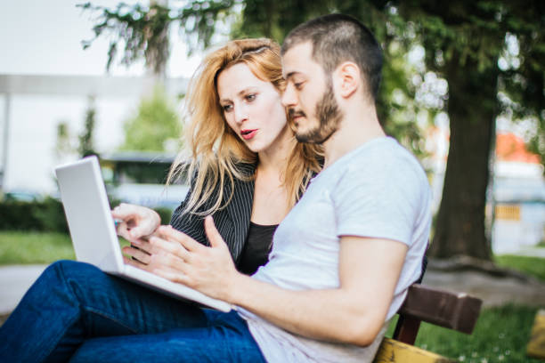 istock Charming couple using laptop in the public park during a lovely sunny day 931531224