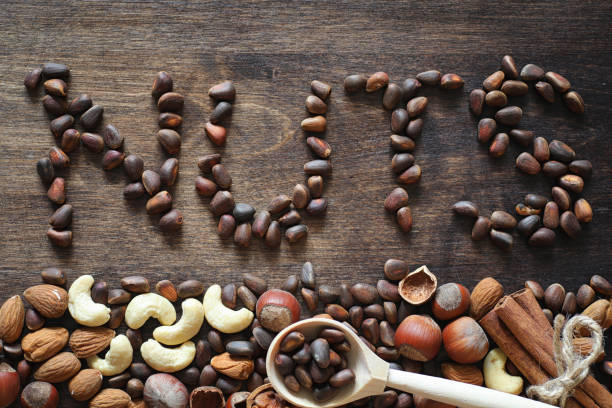 istock Different nuts on a wooden table. Cedar, cashew, hazelnut, walnu 931531298
