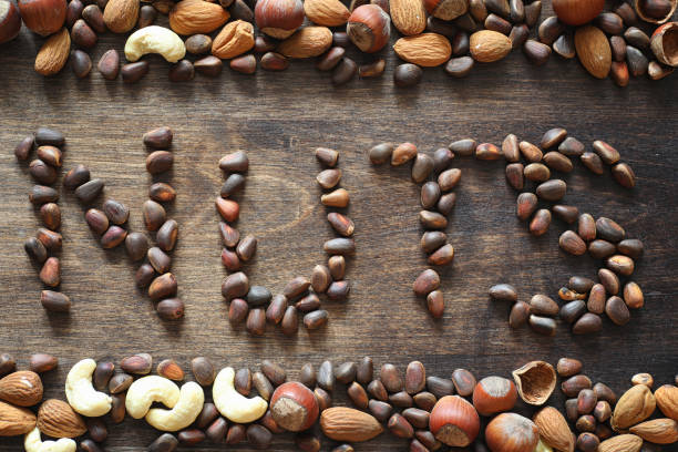istock Different nuts on a wooden table. Cedar, cashew, hazelnut, walnu 931531356