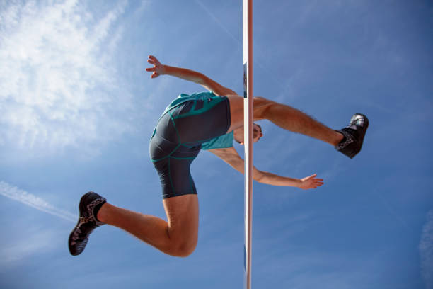 istock Low angle view of determined male athlete jumping over a hurdles 931531422