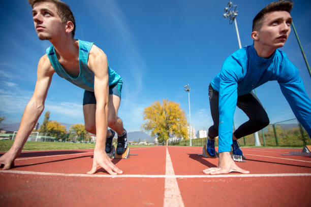 atletas no sprint iniciar a linha na pista e campo - rivalry starting block track and field athlete track and field - fotografias e filmes do acervo