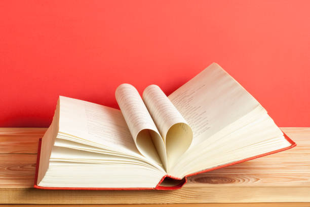 Heart from book page on red background.Free copy space. Education concept.