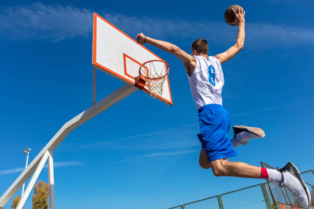 istock Young Basketball street player making slam dunk 931534270