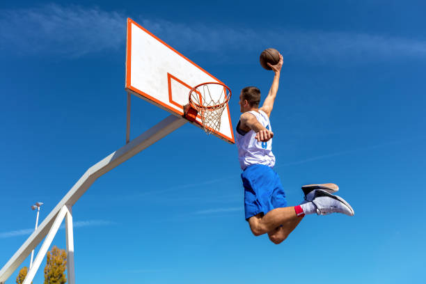 young street basketballspieler machen slam dunk - basketball slam dunk basketball hoop sport stock-fotos und bilder