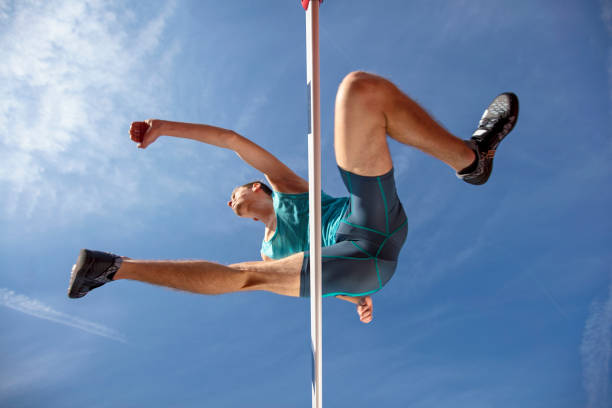 istock Low angle view of determined male athlete jumping over a hurdles 931534484