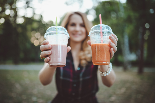 Close-up of a woman enjoying smoothies in the public park