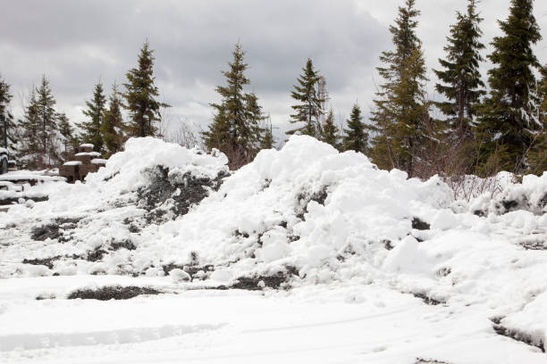 banks of snow that has been plowed with dirt and gravel outside in the winter