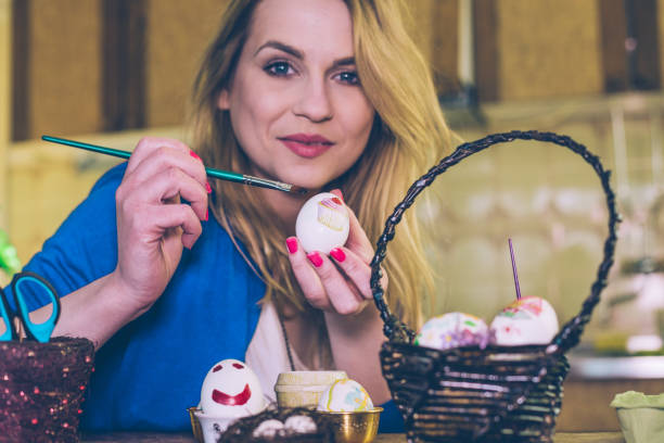 istock Woman decorating Easter eggs for holidays at home 931538308