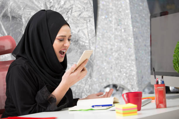 istock Muslim female worker talking on the phone while working with laptop computer 931542670