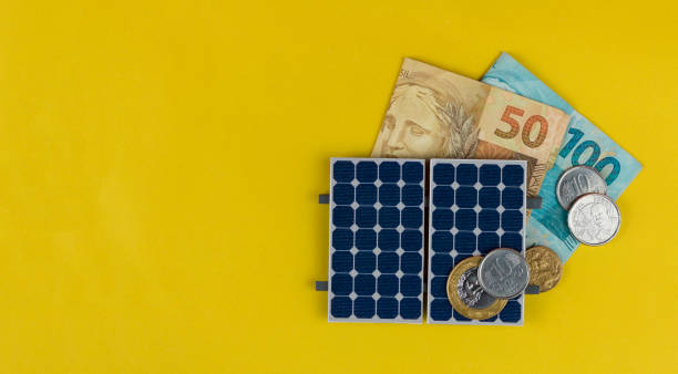 солнечная панель с различными значениями бразильских денег изолированы в желтом фоне. - solar energy currency energy green стоковые фото и изображения