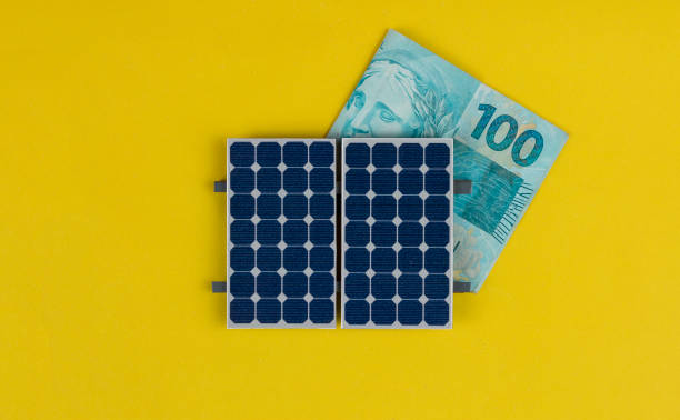 Solar panel with varied values of Brazilian money isolated in yellow background. stock photo