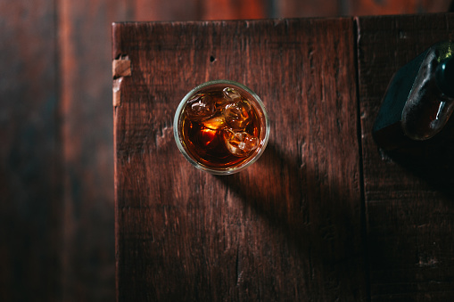 Cold brew coffee with ice cubes on the wooden table from above. Urban coffee shop.