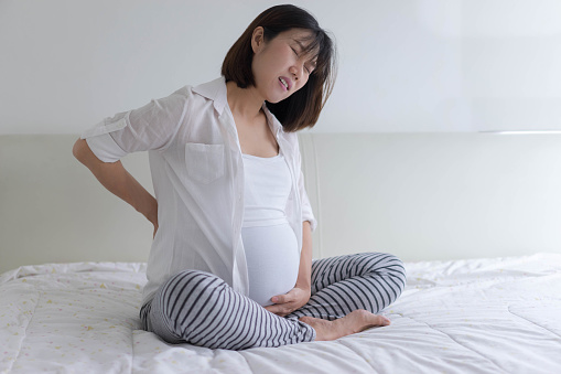 pregnant woman suffer from back pain, cramp, discomfort