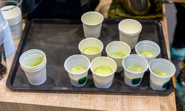 Green milke tea sample in mini white plastic tasting cup on black tray. Marketing promotion for new launched flavor of healthy product. Green milk tea sample in mini white plastic tasting cup on black tray. Marketing promotion for new launched flavor of healthy product. food sample cups stock pictures, royalty-free photos & images