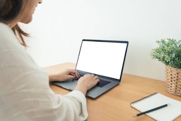 istock Young Asian woman working using and typing on laptop with mock up blank white screen while at home in office work space. Businesswoman working from home via portable computer. Enjoying time at home. 931547838
