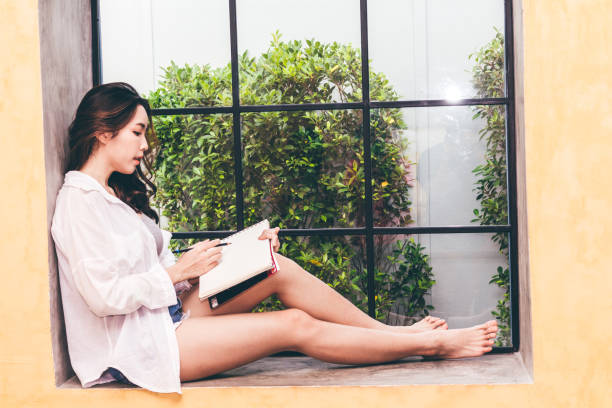 istock Woman with pen writing on a notebook sitting at home 931550200