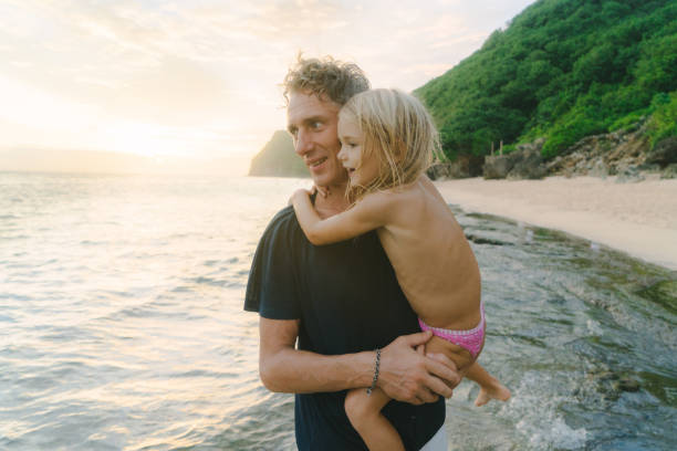Caucasian mature father walking  with little  daughter  on the beach in Bali