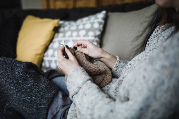 istock Young woman knitting on a sofa 931558062