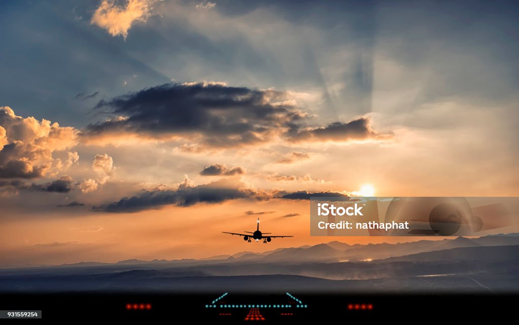 Silueta del avión del aterrizaje a la pista del aeropuerto con la hermosa luz del atardecer - Foto de stock de Avión libre de derechos