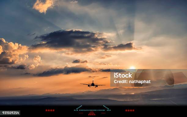 Silueta Del Avión Del Aterrizaje A La Pista Del Aeropuerto Con La Hermosa Luz Del Atardecer Foto de stock y más banco de imágenes de Avión