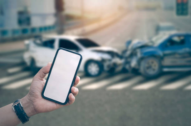 Man hand holding smartphone with blank screen and blur image of car crash accident background Man hand holding smartphone with blank screen and blur image of car crash accident background car accident photos stock pictures, royalty-free photos & images