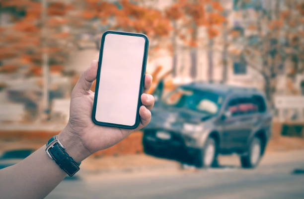 istock man hand holding smartphone with car crash accident background 931559730