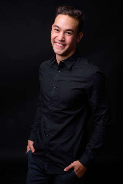 istock Young handsome multi-ethnic businessman against black background 931560368