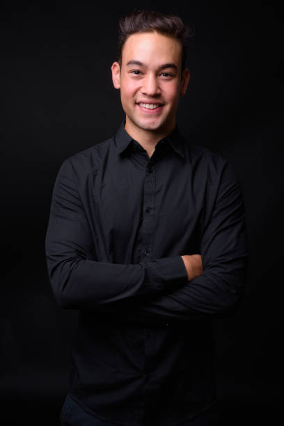 istock Young handsome multi-ethnic businessman against black background 931560394
