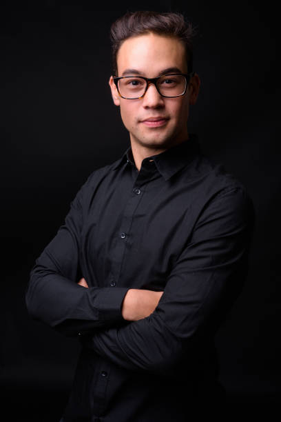 istock Young handsome multi-ethnic businessman against black background 931562438