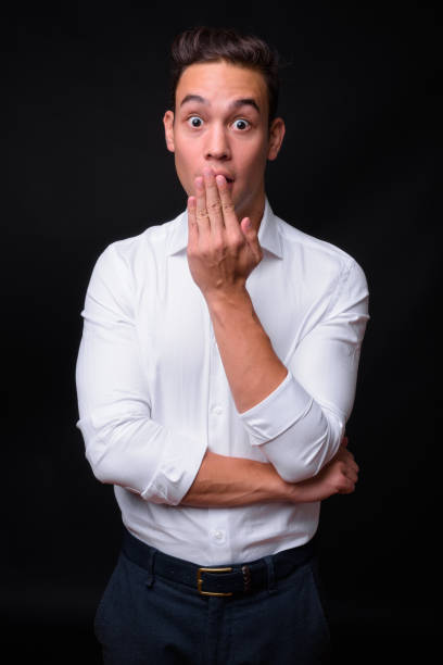 istock Young handsome multi-ethnic businessman against black background 931562560