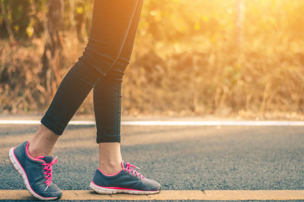 istock Women runner feet on road in workout wellness concept. 931569920