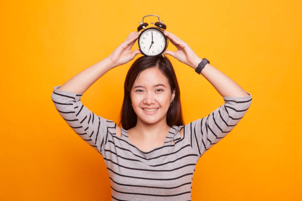 istock Young Asian woman smile with a clock. 931574108