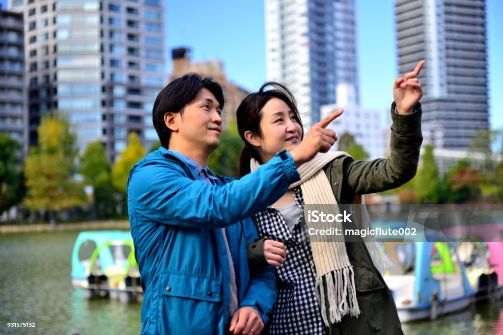 Japanese Couple in Their 30's in Ueno Park, Tokyo Japanese couple in their 30's are enjoying autumn leaf color in Ueno Park, Tokyo, Japan, on a fine autumn day. Couple - Relationship Stock Photo