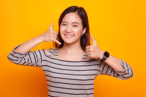 istock Young Asian woman thumbs up show with phone gesture. 931575430