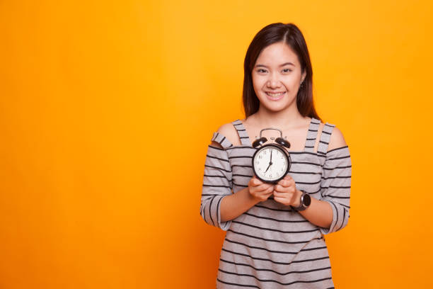 istock Young Asian woman smile with a clock. 931577608