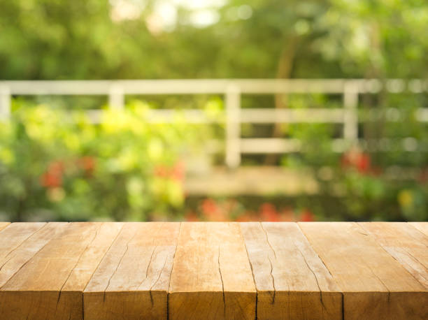 istock Empty wood table top on blur abstract garden and house background 931579928