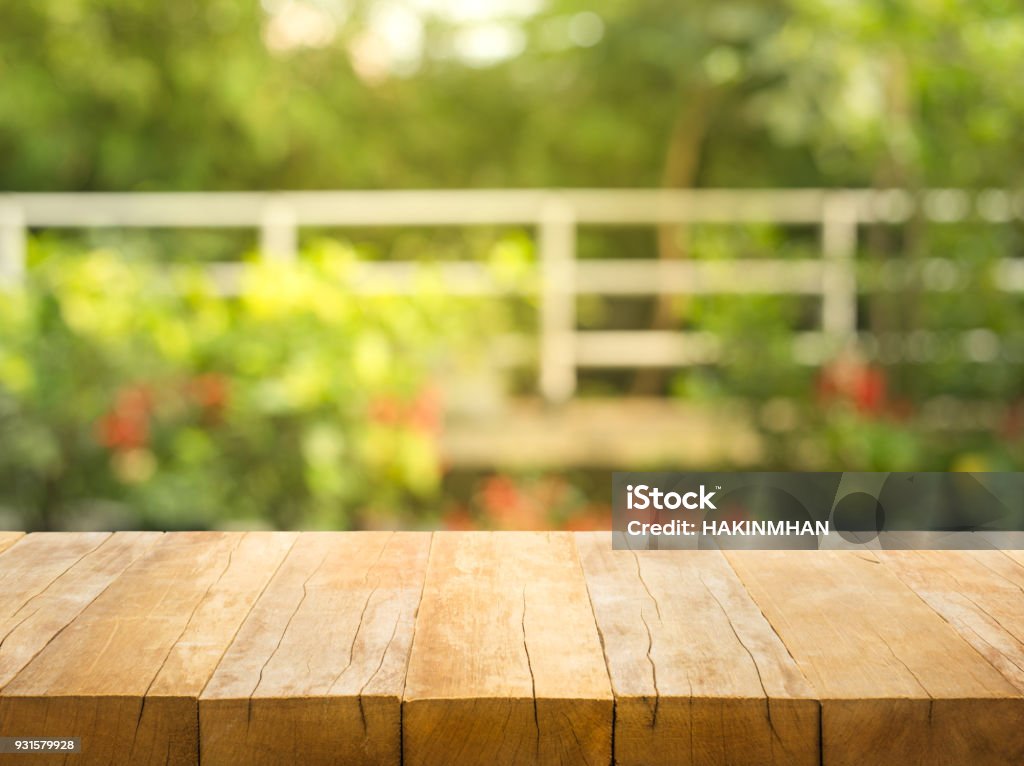 Empty wood table top on blur abstract garden and house background Empty wood table top on blur abstract garden and house background. For montage product display Table Stock Photo
