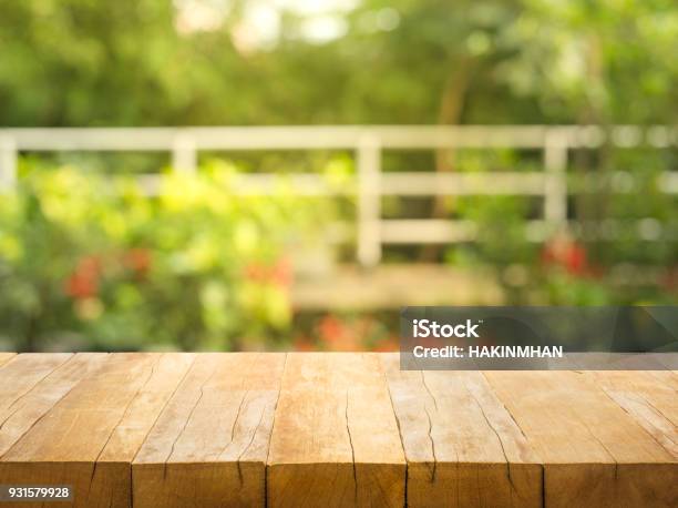 Empty Wood Table Top On Blur Abstract Garden And House Background Stock Photo - Download Image Now