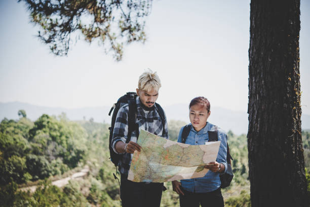 istock Young adventure couple discussing while looking at map during hiking in the mountain. 931582138