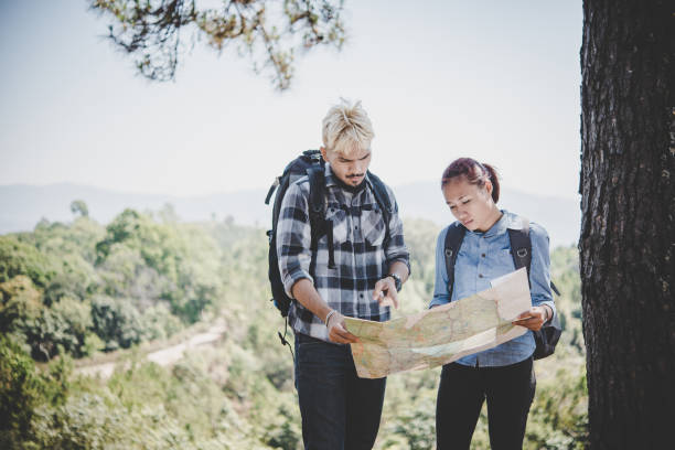 istock Young adventure couple discussing while looking at map during hiking in the mountain. 931582228