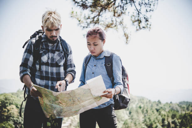 istock Young adventure couple discussing while looking at map during hiking in the mountain. 931582394