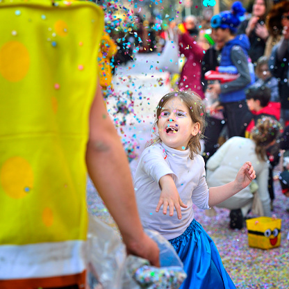 Sion, Switzerland - February 6, 2016: The little girl Tossed confetti in the carnival parade. Sion's carnival, Switzerland.